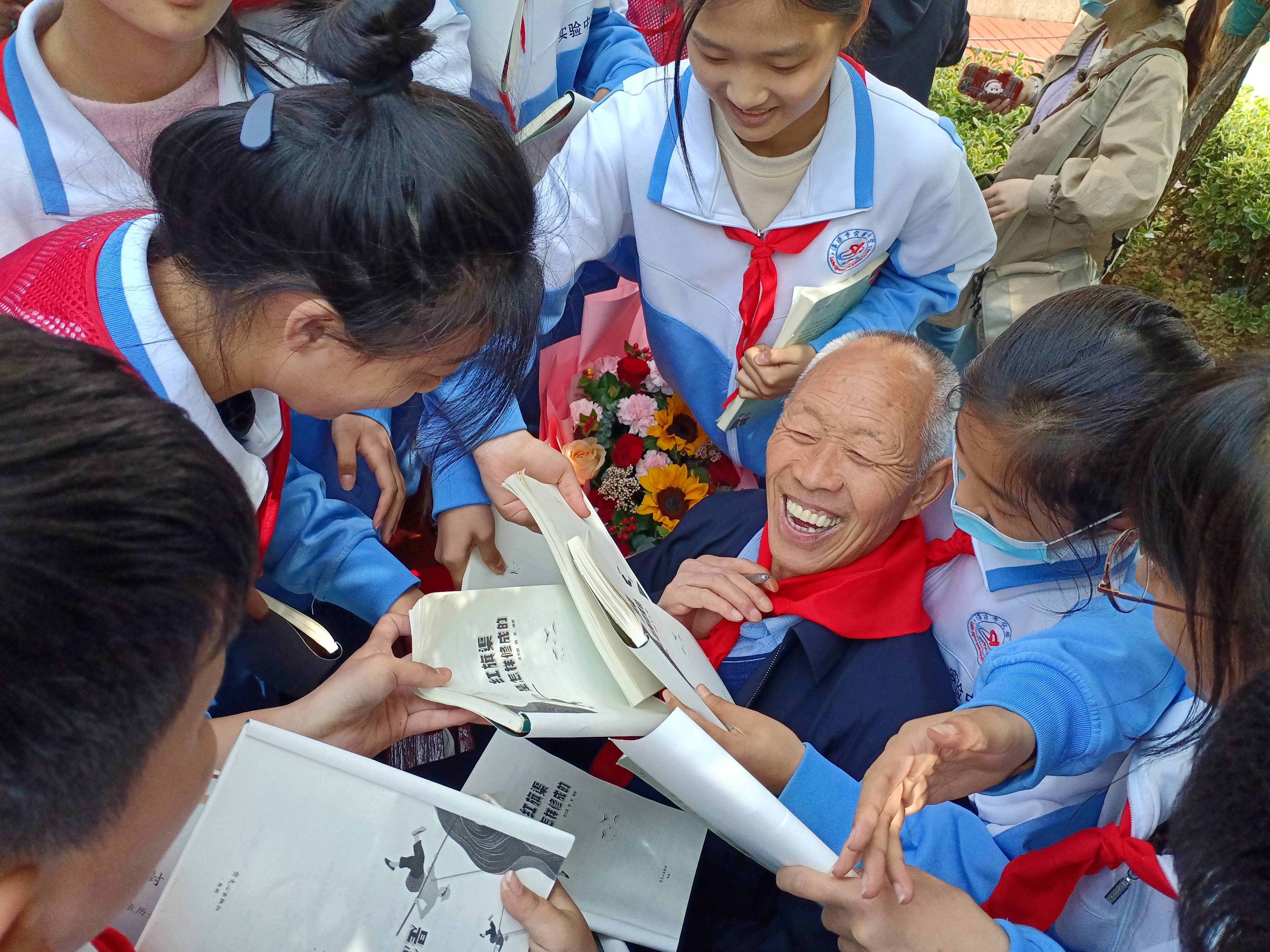 在一次誦讀活動后，孩子們將張買江老人團(tuán)團(tuán)圍住(1).jpg